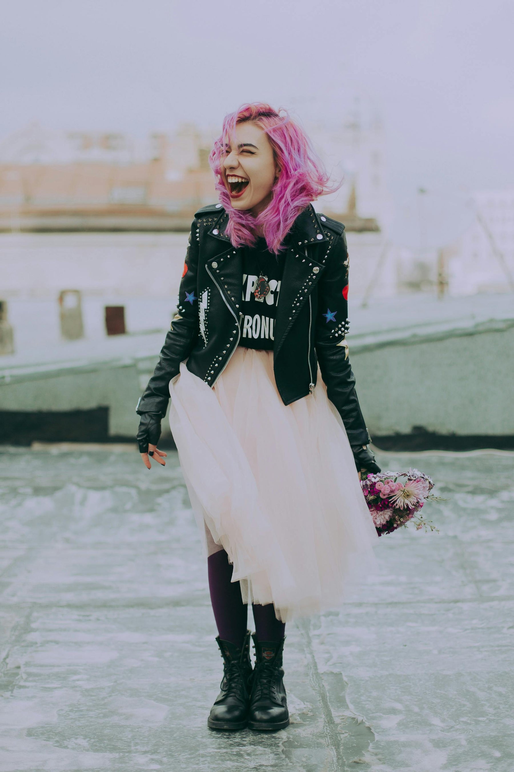 Girl with pink hair, black books, and bomber leather jacket.