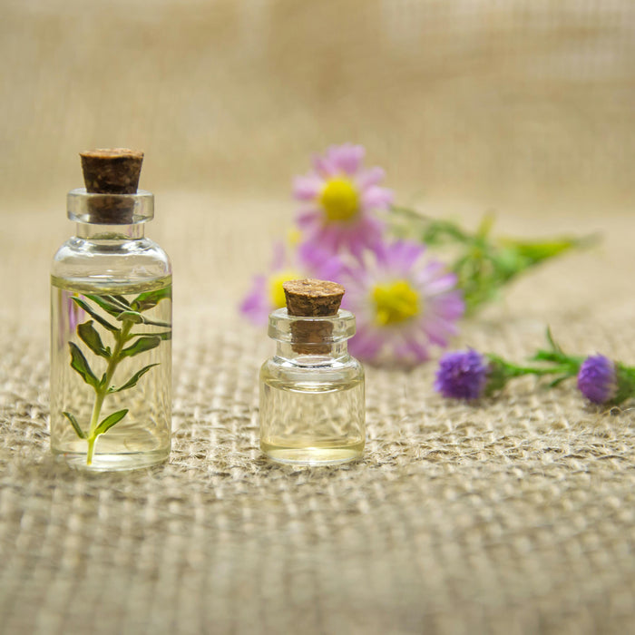Small glass botles filled with oil and botanicals with cork top.
