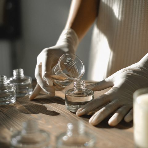 Person filling oils in glass bottle