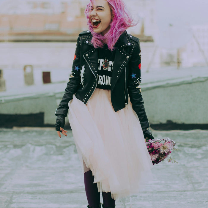 Girl with pink hair, black books, and bomber leather jacket.